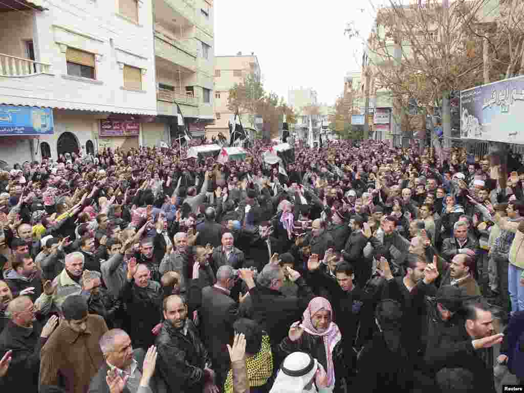 This Shaam news network image shows residents carrying the bodies of men activists say were killed during shelling by forces loyal to Syria's President Bashar al-Assad, Damascus, Syria, November 22, 2012. 