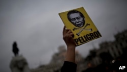 抗議者手舉標語牌，上面是前總統藤森的畫像，下面用西班牙語寫著：危險。(2017年7月7日)