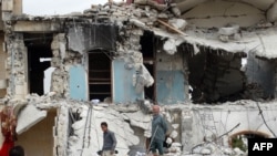 敘利亞人檢查在阿勒波被空襲的某組織總部