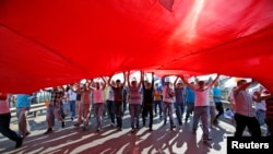 土耳其总理埃尔多安的支持者6月16日在伊斯坦布尔举行集会，撑开一面巨大的土耳其国旗。（照片来源：路透社）