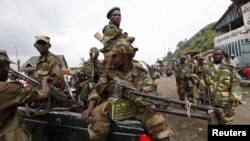 Congolese rebels sit in a truck as they patrol a street in Sake, 25 kilometers north of Goma city soon after the rebels captured the town from the government army, in the eastern Democratic Republic of Congo, November 21, 2012.