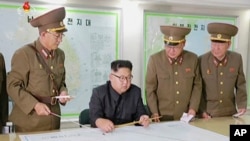Shugaban Korea ta Arewa Kim Jong Un (a zaune) tare da wasu hafsoshin sojin kasar