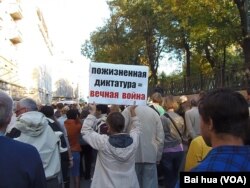 去年9月末的莫斯科大规模反战示威中，一名示威者手举标语：终身独裁等于永远战争 (美国之音白桦拍摄)