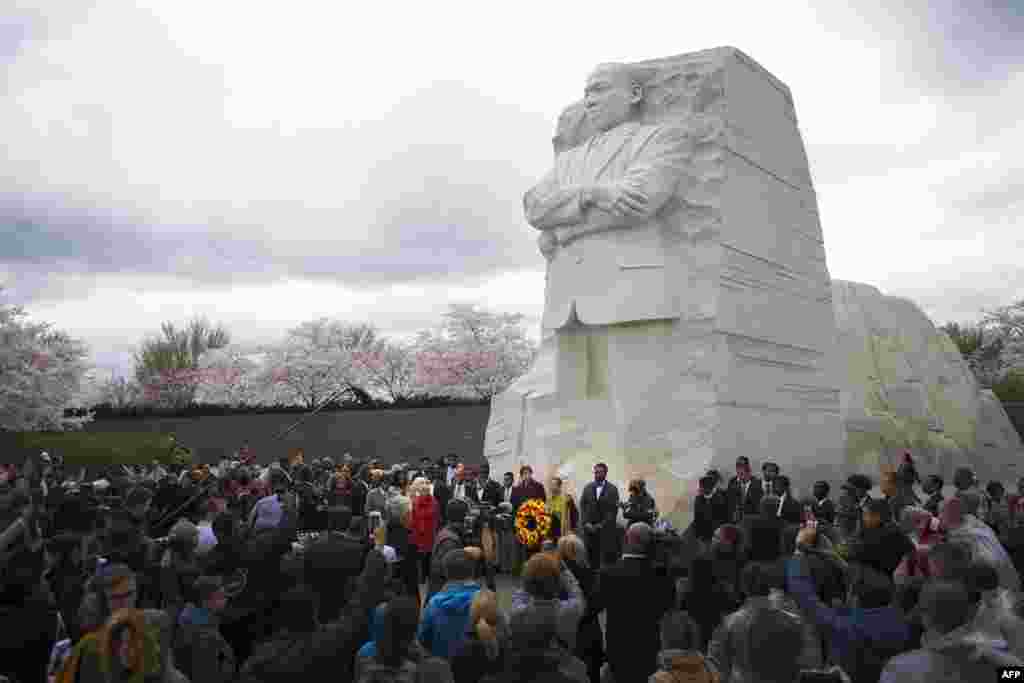 2018年4月4日，华盛顿特区，马丁&middot;路德&middot;金纪念园， 一座高9米的马丁.路德.金雕像之下，人们集会纪念Martin Luther King Jr.牧师遇刺50周年。时值樱花季节。马丁.路德.金雕像由中国雕刻家雷宜锌制作。雕像上，马丁.路德.金从巨石中出现，表情凝重，双臂交叉，左手紧握文稿。