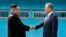 North Korea's leader Kim Jong Un (L) shakes hands with South Korea's President Moon Jae-in (R) at the Military Demarcation Line that divides their countries ahead of their summit at the truce village of Panmunjom