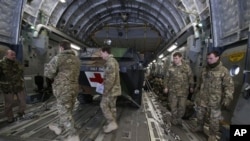 英军人员在停在法国一陆军基地的一架英国C17运输机内装载的法军医疗装甲车前走过。英美都在向法国在马里的行动提供支持。(2013年1月14日)