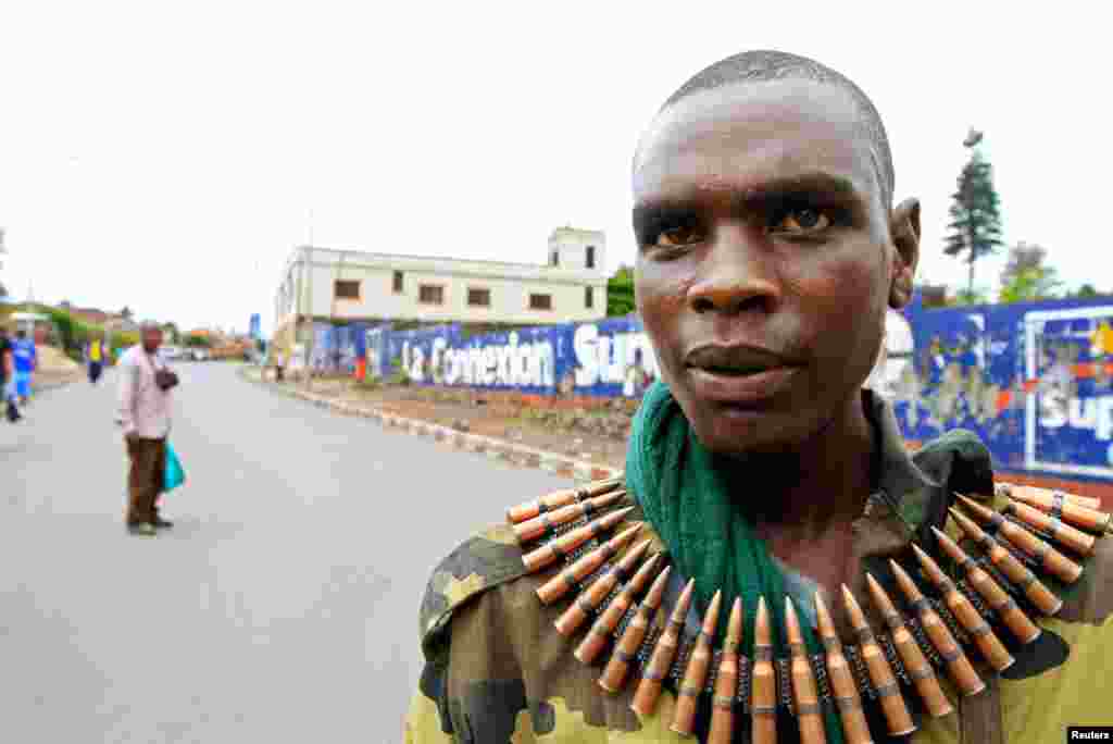 A M23 fighter, wearing a belt of ammunition, walks down a street in Goma, after the rebels captured the city from the government army, November 20, 2012.