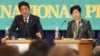 日本自民党党魁和首相安倍晋三(左) 10月8日在政党领袖辩论会中发表讲话。希望之党的领袖小池百合子在一旁聆听。