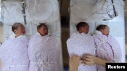 A nurse takes care of quadruplets at a hospital in Shanghai January 11, 2007. China's population will increase by 200 million in 30 years, according to a report published on Thursday, Xinhua News Agency reported. CHINA OUT REUTERS/China Daily (CHINA) - RT