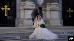 ຄູ່​ຮັກ​ຄູ່​ນຶ່ງ​ກຳ​ລັງ​ຖ່າຍ​ຮູບ​ແຕ່ງ​ງານ​ຂອງ​ເຂົາ​ເຈົ້າ​ຢູ່ນອກ​ໂບດ ຫວັງ​ຟູ​ຈິງ ໃນ​ນະ​ຄອນຫຼວງ ປັກ​ກິ່ງ, 25 ທັນ​ວາ 2020.