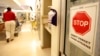 FILE- A sign urging staff and patients to wash their hands hangs on the wall as a patient is wheeled through the emergency room at Greater Baltimore Medical Center in Towson, Maryland, Nov. 3, 2009.