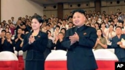 神秘女子(左)陪同金正恩等领导人看完牡丹峰乐队表演后起立鼓掌(7月6日资料照片)