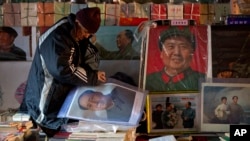 在中共領袖毛澤東冥誕120週年之際，一名舊書販在北京某舊貨市場擺放毛澤東畫像