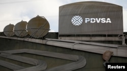ພາບ​ທີ່​ອະ​ທິ​ບາຍການ​ປະ​ຕິ​ບັດ​ການ​ດ້ານ​ນ້ຳ​ມັນ​ສາ​ມາດ​ເຫັນ​ໄດ້​ຢູ່​ຕຶກ​ຂອງ​ບໍ​ລິ​ສັດ​ນ້ຳ​ມັນ​ລັດ​ຖະ​ບານ​ຂອງ ເວ​ເນ​ຊູ​ເອ​ລາ, PDVSA, ໃນ​ນະ​ຄອນຫຼວງ ຄາ​ຣາ​ຄັ​ສ, ເວ​ເນ​ຊູ​ເອ​ລາ, 28 ມັງ​ກອນ 2019.
