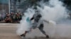 香港一名反送中抗议者把港警发射的一枚催泪弹抛回向港警。（2019年9月29日）