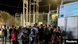 9月19日部份難民和移民在莫里亞難民營發生火災後聚集在入口處