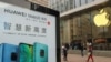 中国上海的苹果商店外面，顾客排队购买新的iPhone XR手机，附近有华为Mate 20系列产品的广告。（2018年10月26日）