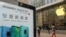 中国上海的苹果商店外面，顾客排队购买新的iPhone XR手机，附近有华为Mate 20系列产品的广告。（2018年10月26日）
