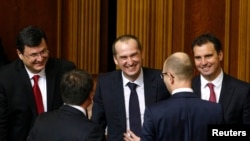 2014年12月2日，烏克蘭總理亞紐采克（右二）在議會開會期間與內閣候選人交談。