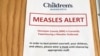 In this May 2, 2017 photo, a sign at the specialty clinic at Children's Minnesota in Minneapolis, alerts patients to a measles outbreak in the area. 