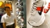 资料照：上海一家商场里一名顾客走过美国运动服装公司产品耐克鞋旁。