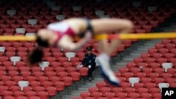 在北京的国际田径赛上，保安人员观看俄罗斯女子运动员跳高（2014年5月21日）