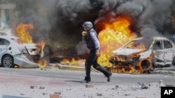 2021年5月11日以色列消防员在被导弹击中的汽车旁。