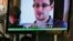 A TV screen shows a news report on Edward Snowden, a former CIA employee who leaked top-secret documents about sweeping U.S. surveillance programs, at a restaurant in Hong Kong, June 12, 2013. 