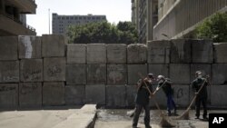 埃及扫街工人在几天示威抗议后清理开罗美国使馆附近地区