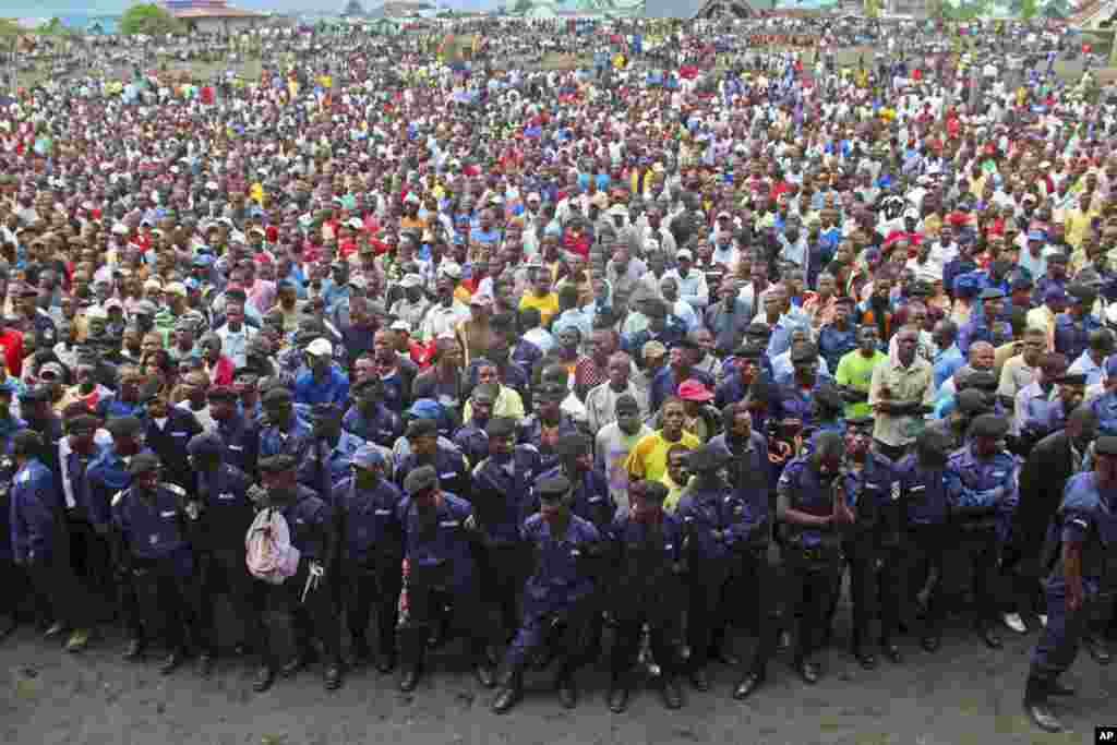 Congo government policemen, foreground, and civilians gather during a M23 rally in Goma, Congo, November 21, 2012.