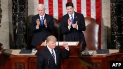 President Donald Trump, flanked by Vice President Mike Pence and House Speaker Paul Ryan of Wis., gestures on Capitol Hill in Washington, Feb. 28, 2017, before his address to a joint session of Congress. 