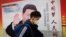 资料照：一名男子走过北京街头中国领导人习近平的宣传画。