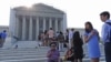 People line up in front of the Supreme Court in Washington, Jun. 24, 2013, before it opened for its last scheduled session. 