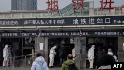 北京地鐵站保安人員身穿防護服檢測地鐵乘客的體溫。 （2020年1月27日）