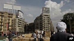 一名男子在开罗解放广场旁观劳工修建基座，准备为2011年被安全部队打死的示威者树立纪念碑。（2013年11月17日）
