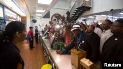 在麥當勞職工為增加工資而罷工期間，勞工運動積極分子和洛杉磯一家麥當勞的經理談話。