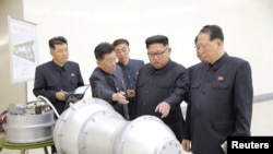 Shugaban Korea ta arewa Kim Jong Un zagaye da mukarrabansa a cibiyar kera makamin nukiliyan kasar, ranar 3, ga watan Satumbar 2017. KCNA via REUTERS 