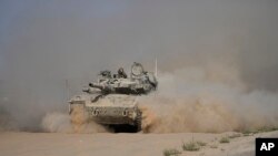 ​ລົດ​ຖັງ ອິ​ສ​ຣາ​ແອ​ລ ເຄືຶ່ອນ​ໄຫວ​ຢູ່​ເຂດ​ຊາຍ​ແດນ​ລະ​ຫວ່າງ ອິ​ສ​ຣາ​ແອ​ລ ແລະ ກາ​ຊາ, ໃນ ອິ​ສ​ຣາ​ແອ​ລ, 12 ກໍ​ລະ​ກົດ 2024. (AP Photo/Tsafrir Abayov)