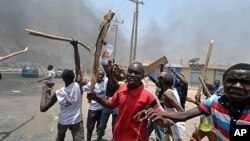 Nan masu zanga-zanga ne dauke da sanduna da barandamai ke zanga-zanga a birnin Kano Arewacin Nigeria, inda ake tafka rikici tsakanin masu zanga-zanga da jami'an soja ran litinin 18 ga watan Afrilun shekarar 2011,bayan fara bayyana sakamakon zaben dake n