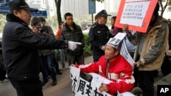 2013年1月10日广州警察手指《南方周末》事件示威者，然后把这位轮椅上的示威者带走了。