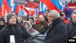 3月1日的莫斯科大游行哀悼遇害的反对派领袖涅姆佐夫。施奈德尔（前排左一），前总理卡西亚诺夫（前排左二）和小卡尔穆尔扎（手持红玫瑰）在涅姆佐夫的遇害地点。（美国之音白桦拍摄）