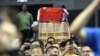 A fan drapes a Chinese national flag over an NBA banner during a preseason NBA basketball game between the Brooklyn Nets and Los Angeles Lakers at the Mercedes Benz Arena in Shanghai, China, Oct. 10, 2019.
