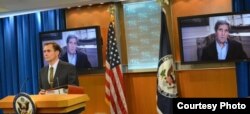 克里国务卿通过视讯从波士顿欢迎正式在简报室登场的新任发言人柯比（照片：美国国务院）