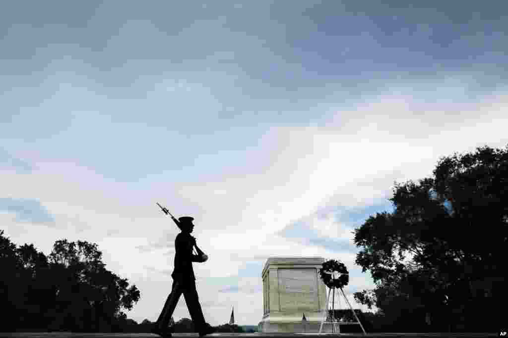 在华盛顿郊区的阿灵顿国家公墓，美国陆军第三步兵团的一位军人走向无名战士墓前面站岗（2018年5月27日）。阿灵顿国家公墓毗邻陆军基地，也是号称&ldquo;老卫队&rdquo;的美国陆军第三步兵团的驻地。