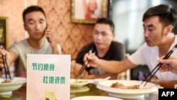 中國河北邯鄲市一家餐館桌子上立有“節約糧食杜絕浪費”的牌子。 （2020年8月13日）