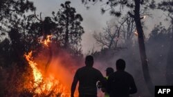 Wafanyakazi wa zimamoto wakikabiliana na moto katika mji wa Mellouta kwenye mpaka wa Algeria. July 24, 2023.