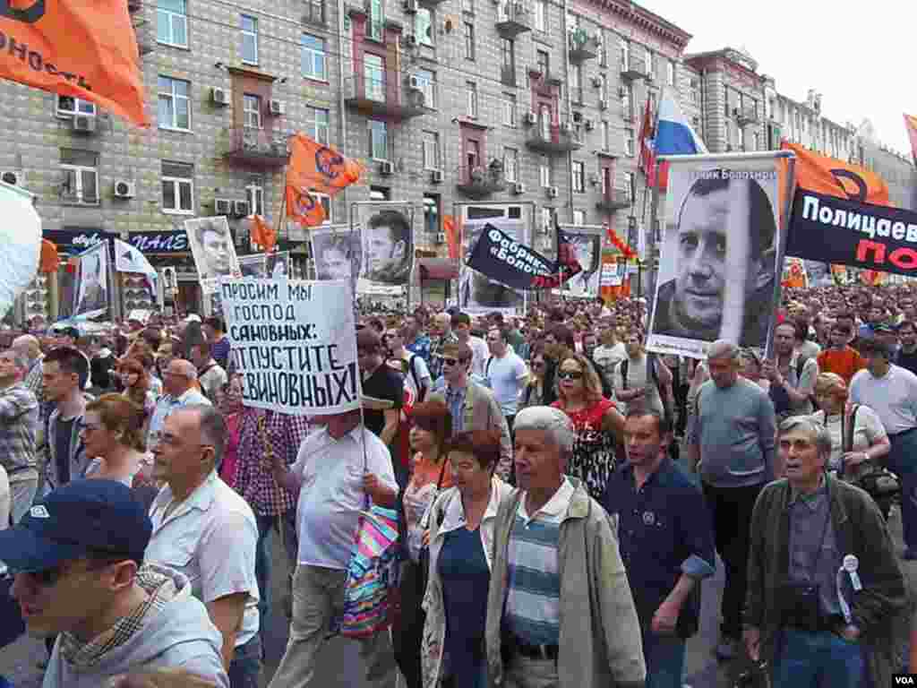 示威者手举被捕反对派人士画像。