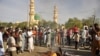 People gather at the site of a bomb explosion in Kano, Nigeria, Friday Nov. 28, 2014. An explosion tore through the central mosque in Nigeria's second-largest city on Friday, and officials feared the casualty toll would be high. Capt. Ikechukwu Eze said t
