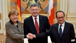 烏克蘭總統波羅申科在2月5日在基輔和到訪的法國總統奧朗的以及德國總理默克爾握手。