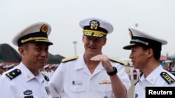 2014年8月5日美国海军第七舰队旗舰访问中国山东省青岛港： 舰队司令罗伯特·L·托马斯（中）与中国北海舰队司令员袁誉柏（左）交谈